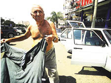 Andrew Blair holding up his shirt outside his hotel 