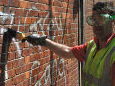 A council worker removes graffiti