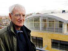 John Sutherland on his balcony with the block in the background