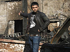 Rezuar Rahaman stands on the rubble where his stall once did – he lost £80,000 worth of stock in the fire