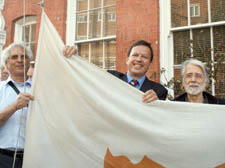 George Eugeniou, right, Chris Sekkides and Peter Droussiotis raise the flag