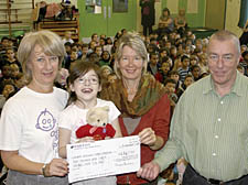 Naomi Angel of Great Ormond Street Hospital, left, receives the cheque from pupil Vicky Cole, Imogen Sharp from the school&rsquo;s parent teacher association, and Gospel Oak headteacher Alan Seymour