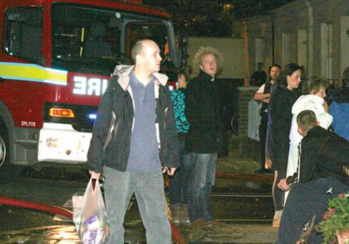 Neighbours ­evacuated from their homes watch firefighters tackle the blaze
