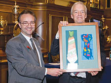 Jon Snow receives an art work produced by children, from TreeHouse chief executive Ian Wylie 