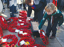 A young Cub Scout places a wreath on Remembrance Day