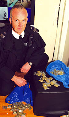 Sgt Chris Walsh with bags of drugs found inside the Firm Cut shop