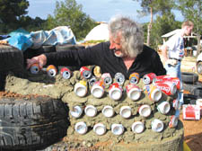 Michael Reynolds works on a can wall in New Mexico