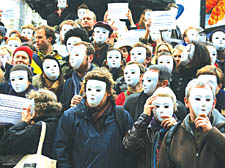 Protesters who work in theatre gather in Piccadilly Circus wearing white masks