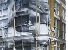 JR's subject might be peeping, but passers-by can't help but stop and stare at his massive work in Lexington Street.